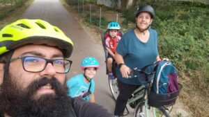 famiglia felice in bicicletta nella ciclabile del trammino