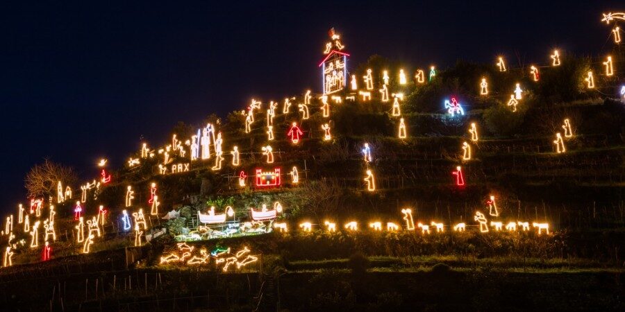 luci che illuminano la collina, in alto ben visibile la capanna con la sacra famiglia