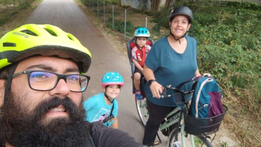 famiglia felice in bicicletta nella ciclabile del trammino